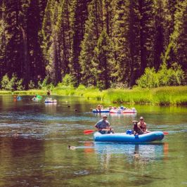 a group of people riding on the back of a boat in the water