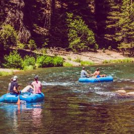 a group of people riding on the back of a boat in the water
