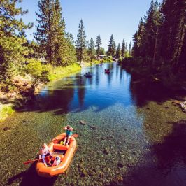 a group of people sitting on the side of a lake