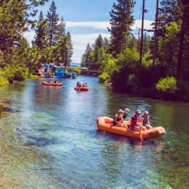 a group of people riding on the back of a boat in the water